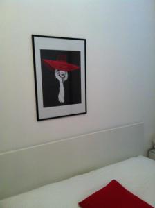 a picture of a woman wearing a red hat on a wall at Apartmani Antunović Podgora in Podgora
