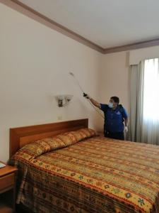 un hombre en una habitación de hotel con una máscara en una cama en Hotel Astromundo, en Reynosa