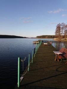 a dock with a table and benches on the water at Apartament Makowo in Makowo