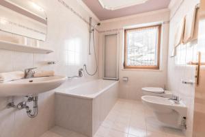 un bagno bianco con lavandino e WC di Tlisüra a La Villa Altre 22 foto