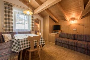 una cucina e una sala da pranzo con un tavolo e un divano di Tlisüra a La Villa