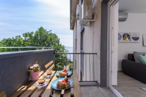 - un balcon avec deux assiettes de nourriture sur une table dans l'établissement Apartment Pearl of Kvarner , Opatija, à Opatija