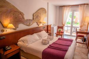 une chambre avec un lit avec une grande tête de lit en bois dans l'établissement Villa Guadalupe, à Malaga