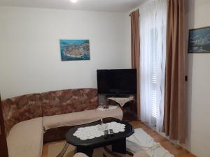 uma sala de estar com um sofá e uma mesa em Vila Ruža em Ston
