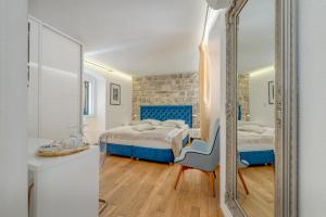 a bedroom with two beds and a mirror at Guesthouse Imperator in Split