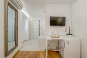 a white hallway with a mirror and a vanity with a mirror at Guesthouse Imperator in Split