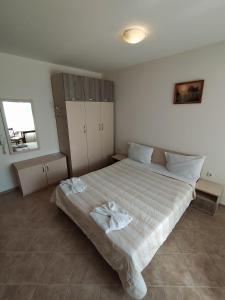 a bedroom with a large bed with white sheets at Sunny Sands Studios in Burgas