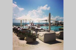 a swimming pool with lounge chairs and umbrellas at Incredible Ocean Views! Terrace, 1800 sq.ft., Hotel in Miami Beach