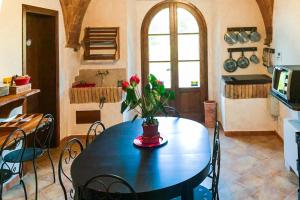 una cocina con una mesa con un jarrón de flores. en In Canto Sul Poggio en Volterra