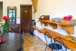 una cucina con bancone e tavolo con sedie di In Canto Sul Poggio a Volterra