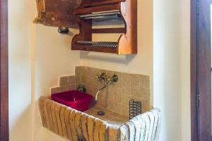 a bathroom with a red sink and a fan at In Canto Sul Poggio in Volterra