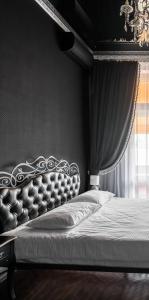 ein Schlafzimmer mit einem Bett mit großem Kopfteil und einem Fenster in der Unterkunft Apartment Secret Place in Lwiw