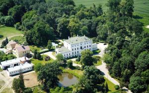 an aerial view of a large white house with trees at Pałac Bałoszyce in Susz