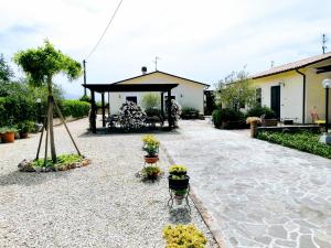 スペッロにあるResidence Terra Dei Santi Country Houseのガゼボと鉢植えの植物がある庭園