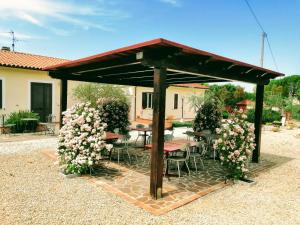 斯佩洛的住宿－Residence Terra Dei Santi Country House，一个带桌椅和鲜花的凉亭