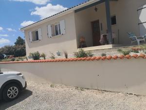 un coche blanco estacionado frente a una casa en Brigitte room, en Barro