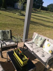 2 sillas y un sofá en un patio con mesa en Brigitte room en Barro