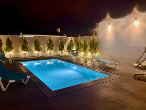 a swimming pool in a backyard at night at Janota Week with pool in Setúbal