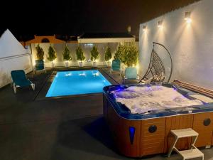 a bath tub sitting next to a swimming pool at Janota Week with pool in Setúbal +15 photos