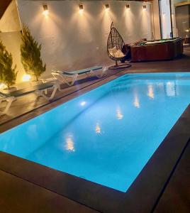 a large swimming pool in a hotel room with chairs and a chair at Janota Week with pool in Setúbal