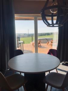 - une table et des chaises dans une chambre avec fenêtre dans l'établissement Lodge spa, à Petit-Réderching