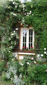 a window with flowers in front of a building at Forest Farm in Bois-Jérôme-Saint-Ouen