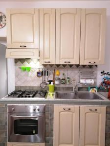 eine Küche mit weißen Schränken und einer Spüle aus Edelstahl in der Unterkunft Casa Francesca in Mailand