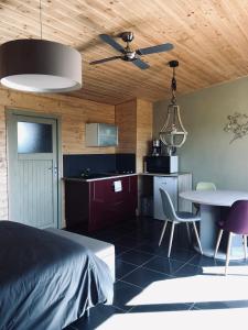 a bedroom with a bed and a table and a kitchen at Lodge spa in Petit-Réderching