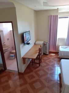 a room with a table and a room with a bedroom at Hotel Litoral in Aracaju
