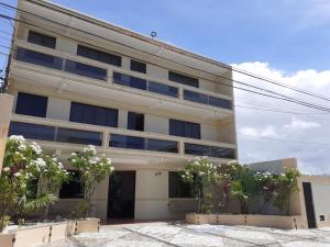 a white building with plants in front of it at Hotel Litoral in Aracaju