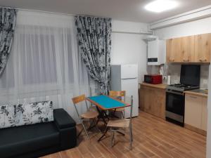 sala de estar con mesa y cocina en Apartament la malul Marii Negre 2, en Mamaia Nord – Năvodari