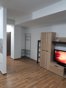 sala de estar con TV y suelo de madera en Apartament la malul Marii Negre 2, en Mamaia Nord – Năvodari