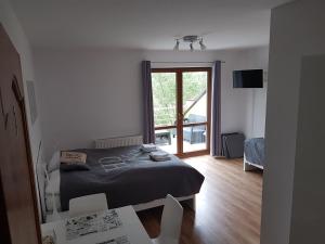 1 dormitorio con cama y ventana grande en TOBI-pokoje gościnne en Łeba