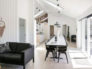 comedor y sala de estar con mesa y sillas en Nine-Bedroom Holiday home in Idestrup 2, en Bøtø By