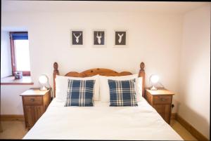 1 dormitorio con 1 cama con almohadas azules y blancas en The Old Boathouse en Wormit