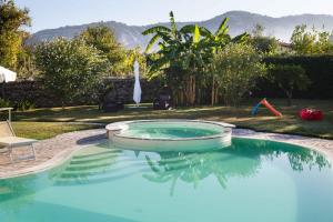 einen Pool in einem Garten mit einem Stuhl in der Unterkunft Selenite in Capo dʼOrlando