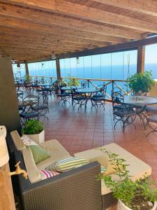 a patio with tables and chairs and tables and the ocean at Agriturismo Sant'Alfonso in Furore