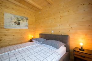 a bedroom with a bed in a wooden cabin at Holiday home Natura in Slunj