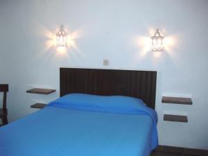 a bedroom with a blue bed and two lights on the wall at Apartamentos Turisticos Marsol in Lagos