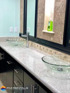 een badkamer met 2 glazen wastafels op een aanrecht bij Linda Vista 106 in Puerto Peñasco