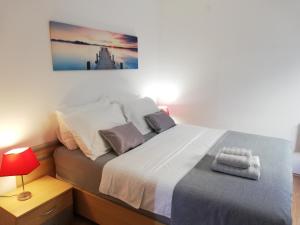 a bedroom with a large bed with a red lamp at Lovely apartment Branko Rabac with balcony and parking in Rabac