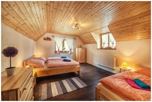 1 Schlafzimmer mit 2 Betten und Holzdecke in der Unterkunft Chata Margitka in Dúbrava