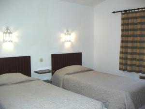 a room with two beds and two lights on the wall at Apartamentos Turisticos Marsol in Lagos