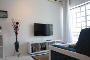 Apartamento com Piscina em Albufeira, Praia da Oura في ألبوفيرا: غرفة معيشة مع تلفزيون وأريكة زرقاء