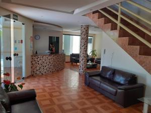 a woman standing in a living room with a staircase at Hotel Litoral in Aracaju