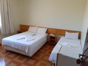 two beds in a hotel room with towels on them at Hotel Litoral in Aracaju