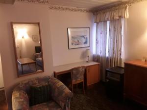 a living room with a couch and a mirror at Hotel Feiler in Muggendorf