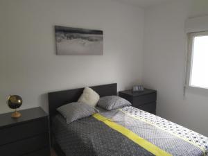 um quarto com uma cama com duas almofadas em Agréable T2 au calme proche gare em Perpignan