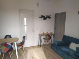 ein Wohnzimmer mit einem blauen Sofa, einem Tisch und Stühlen in der Unterkunft Agréable T2 au calme proche gare in Perpignan