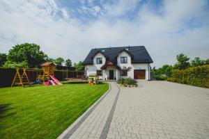 ein Haus mit Spielplatz im Hof in der Unterkunft Pokoje Gościnne Amir in Karwieńskie Błoto Pierwsze